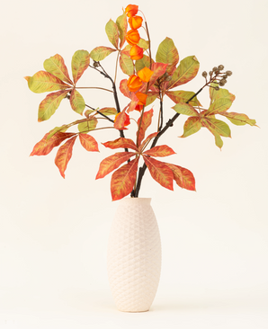Silk konstgjorda blombuketten Autumn Flair har en vas med vit struktur och lyktgren, orange lyktformade blommor och grönröda blad, som bildar en stilfull höstuppvisning mot en enkel ljus bakgrund.
