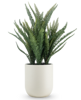 Den konstgjorda Boston Fern 82 cm har långa, smala gröna blad och kommer i en enkel rund vit kruka, mot en vanlig vit bakgrund.