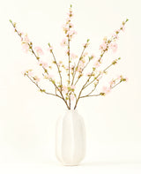 Sidens konstgjorda blombukett Körsbärsblommor ljusrosa 94 cm har känsliga rosa konstgjorda körsbärsblommor i en vit keramikvas, som tillför elegans mot en vanlig ljus bakgrund.