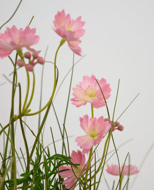 Konstgräs Rosa Gesang Flower Onion Grass Pot 56cm Fire Retardant har känsliga rosa blommor med smala gröna stjälkar och smala blad, arrangerade mot en ljus bakgrund för en mjuk, luftig effekt.
