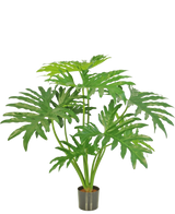 Den konstgjorda växten Philodendron 80 cm är en konstgjord växt med stora, delade gröna blad i en liten svart kruka, avbildad mot en vanlig vit bakgrund.