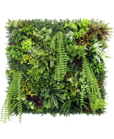 Artificiell Hedge Lush Deco Deluxe 100x100 cm UV är en kvadratisk vertikal trädgårdspanel med tät, strukturerad grönska med en blandning av lövväxter, ormbunkar och gräs - perfekt för att skapa en levande naturlig visning mot en vit bakgrund.