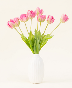De Zijden kunstbloemen boeket Franse Tulp roze is gerangschikt in een witte vaas, met roze Franse tulpen en groene bladeren tegen een eenvoudige lichte achtergrond.