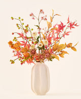 Konstgjord sidenblommabukett 'Autumn Breeze' i en vit keramikvas, med arrangemang av höstlöv, små gröna bär, rosa blommor och vita blommor, gjorda av högkvalitativa sidenblommor. Placerad mot en ljus bakgrund – den perfekta konstgjorda blombuketten för att ge alla rum en långvarig säsongsbetonad atmosfär.