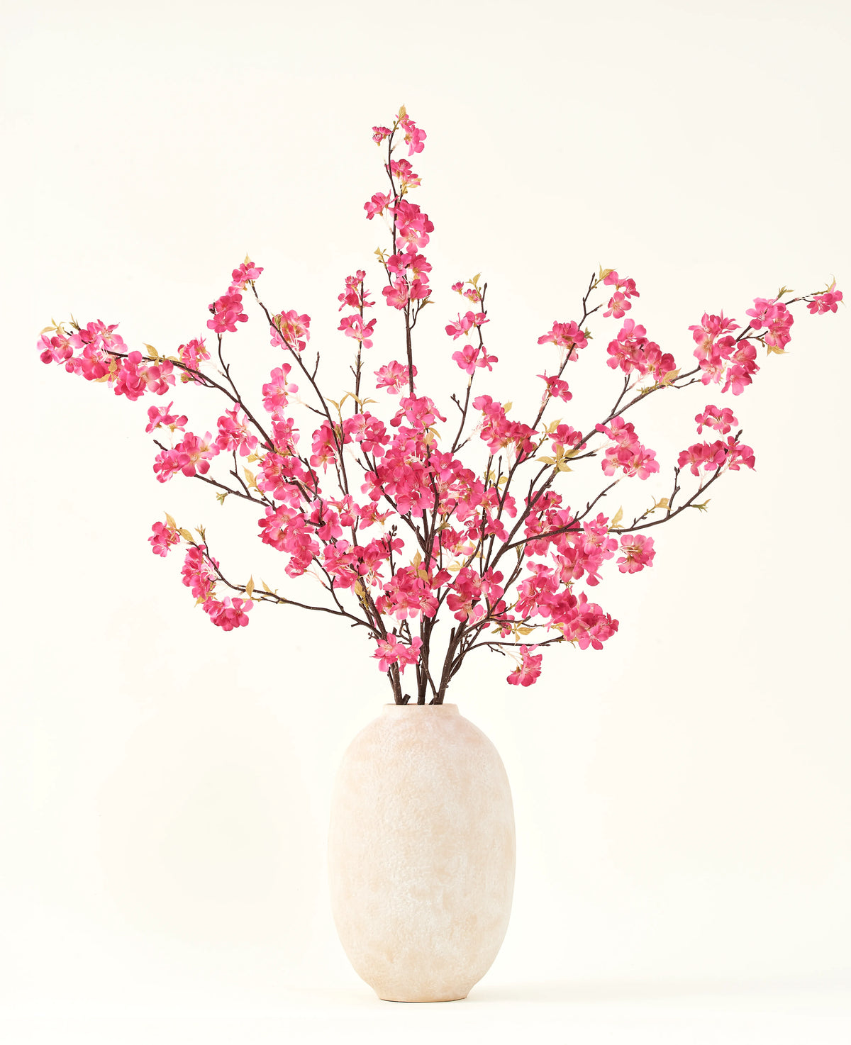 Silk konstgjorda blombuketten Cherry blossom fuchsia 150 cm har livfulla fuchsia körsbärsblomma stjälkar med gröna blad i en enkel vit vas, som kommer att komplettera alla interiörer mot en ljus bakgrund.
