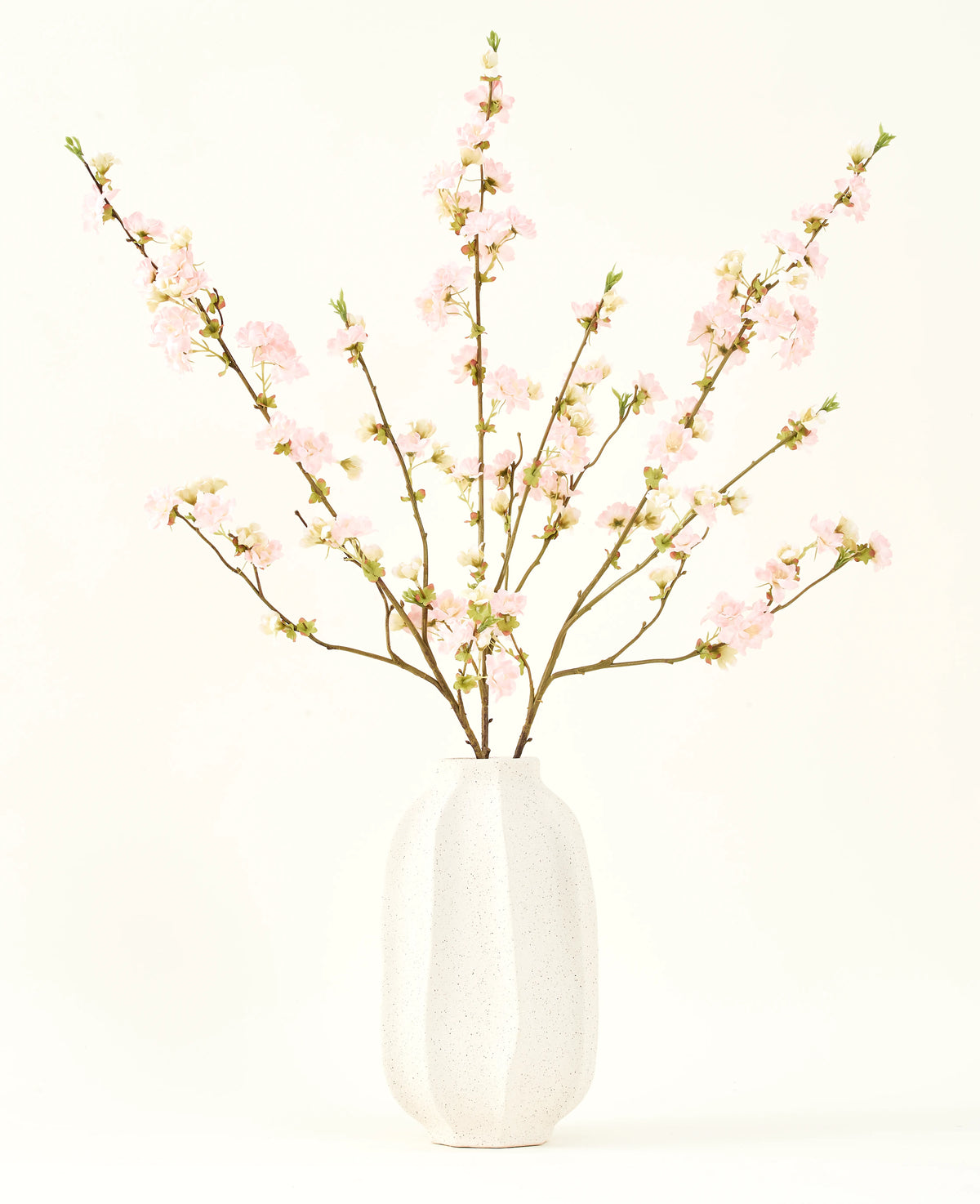 Sidens konstgjorda blombukett Körsbärsblommor ljusrosa 94 cm har känsliga rosa konstgjorda körsbärsblommor i en vit keramikvas, som tillför elegans mot en vanlig ljus bakgrund.