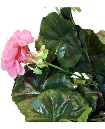 En närbild av den konstgjorda pelargonen 40 cm rosa, med flera gröna blad mot en vit bakgrund.