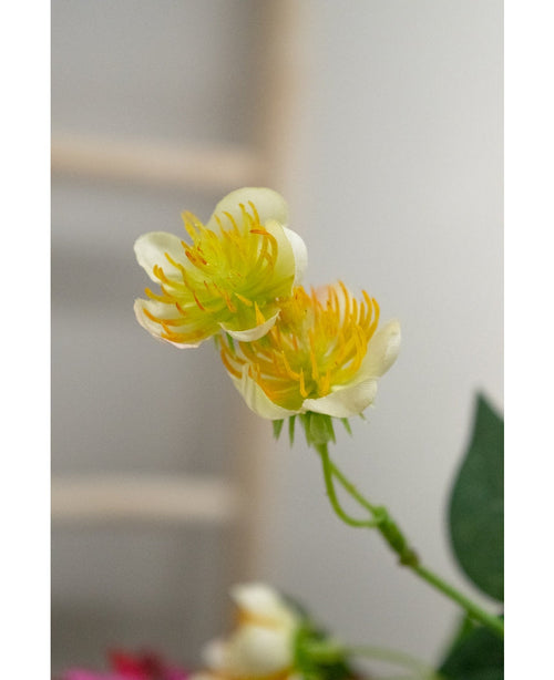 Närbild av den konstgjorda blommanssmörblomman 77 cm i gult och vitt, med gröna stjälkar och blad mot suddig bakgrund - perfekt för alla som vill skapa en bukett med vackra konstgjorda blommor.