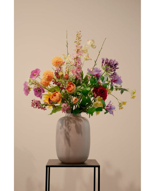 Artificiell kornell Real Touch Light Yellow 74cm, en verklighetstrogen ljusgul konstgjord blomma, står i en keramikvas med grönt bladverk på ett svart metallstativ mot en enkel beige bakgrund.
