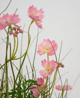 Konstgräs Rosa Gesang Flower Onion Grass Pot 56cm Fire Retardant har känsliga rosa blommor med smala gröna stjälkar och smala blad, arrangerade mot en ljus bakgrund för en mjuk, luftig effekt.