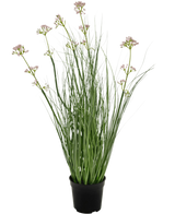 Konstgräs Purjolök Blomma Lök Gräs Bonsai 61 cm brandskyddsmedel har långa, smala gröna blad och långa stjälkar med små klasar av ljuslila blommor, presenterade i en kruka mot en vanlig vit bakgrund.