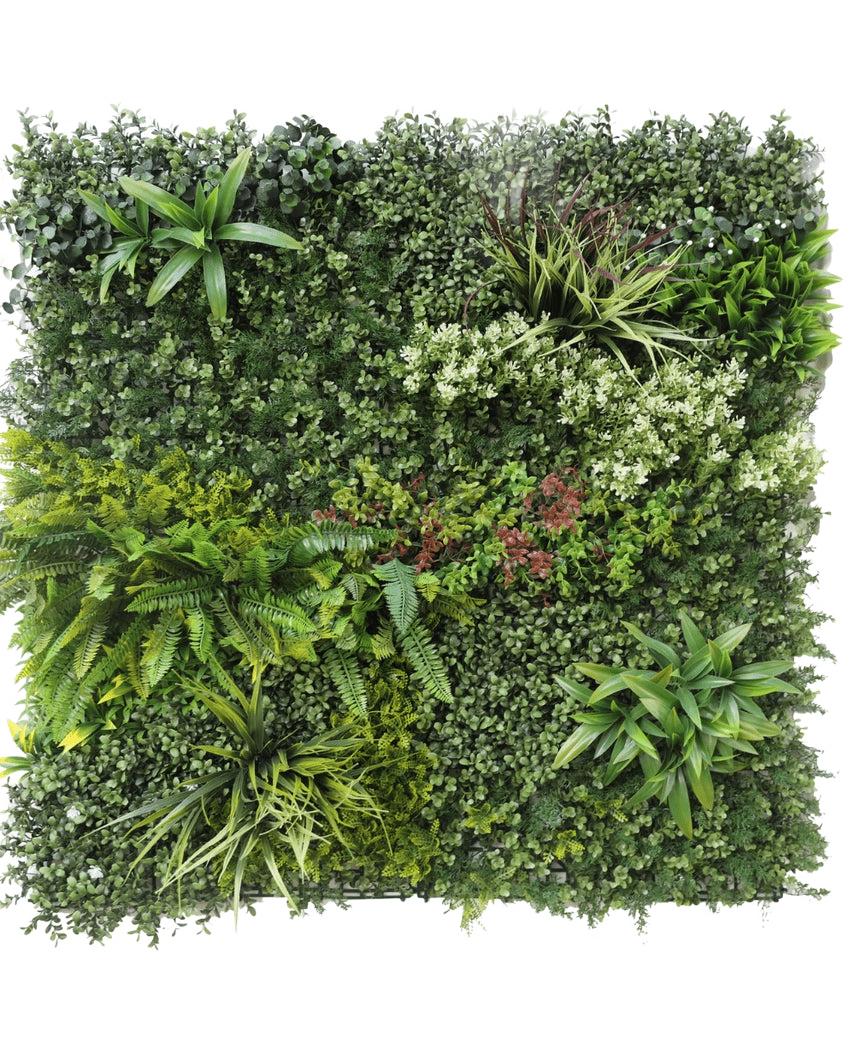Artificiell Hedge Prestige 100x100 cm UV är en fyrkantig panel av konstgjorda gröna bladverk med blandade bladväxter, ormbunkar, varierande texturer och gröna nyanser, plus klasar av små vita och röda blommor. Bakgrunden är vit.